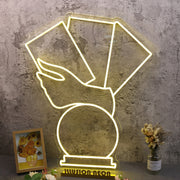 A Hand Holding Books Yellow Neon Sign